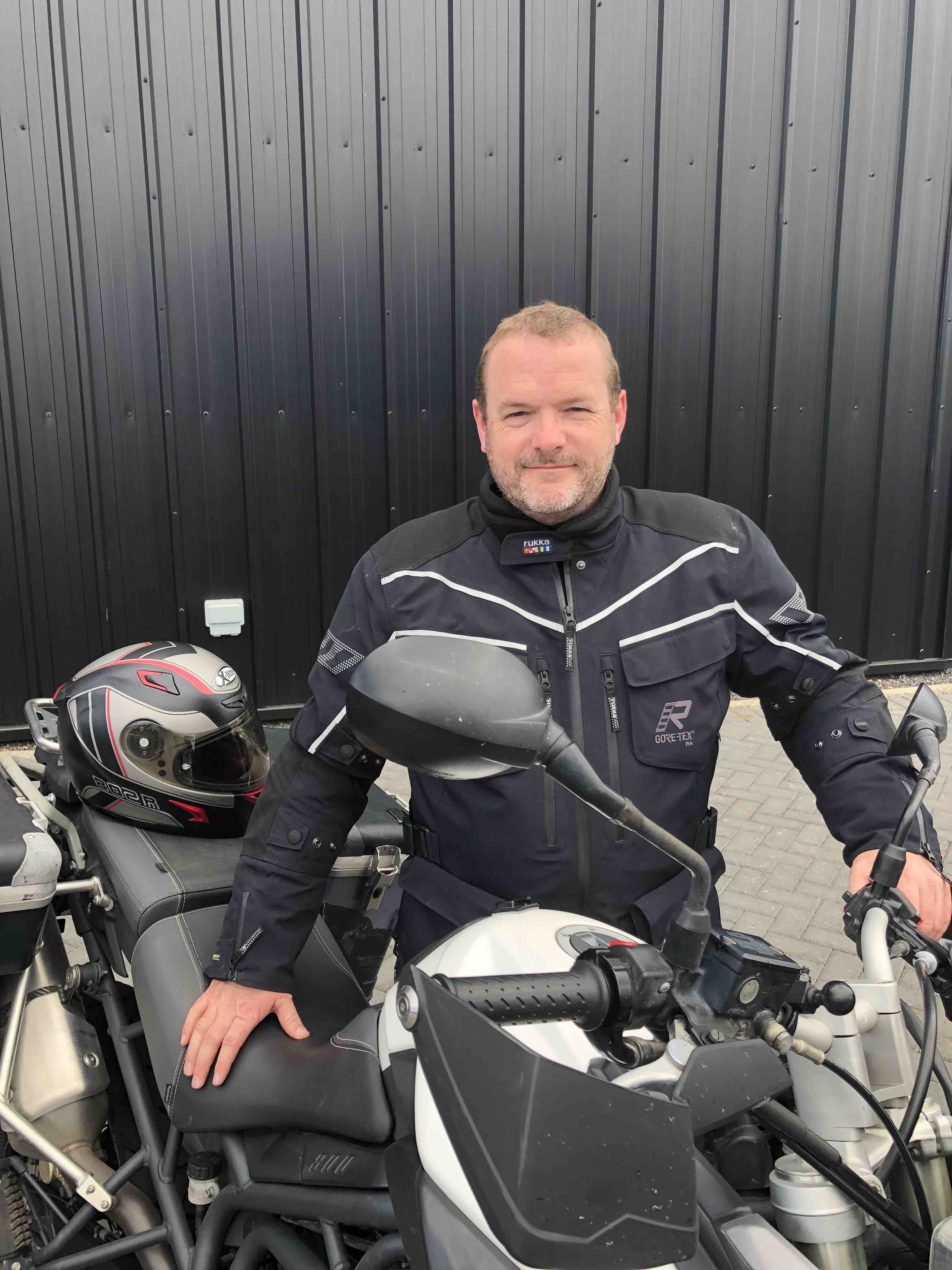Man standing next to motorcycle